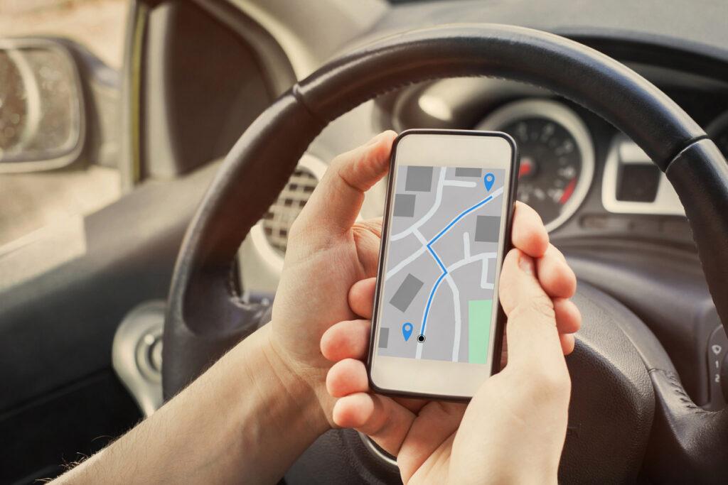 Driver using a GPS map on the screen of a smartphone in a car.