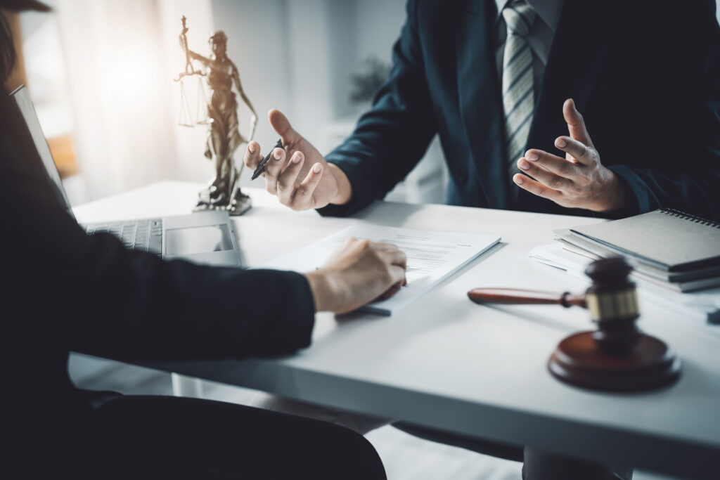 Client holding a pen while consulting with a defense attorney.