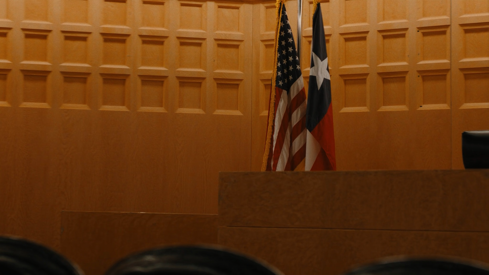 Texas courtroom with the United States and Texas flags.