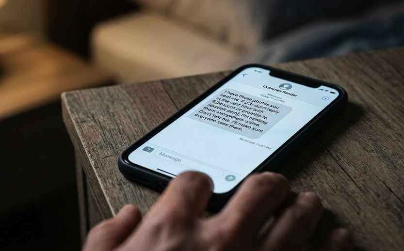 A threatening text message demanding money or intimate photos, an example of the coercion criminalized by Texas Penal Code 21.16.